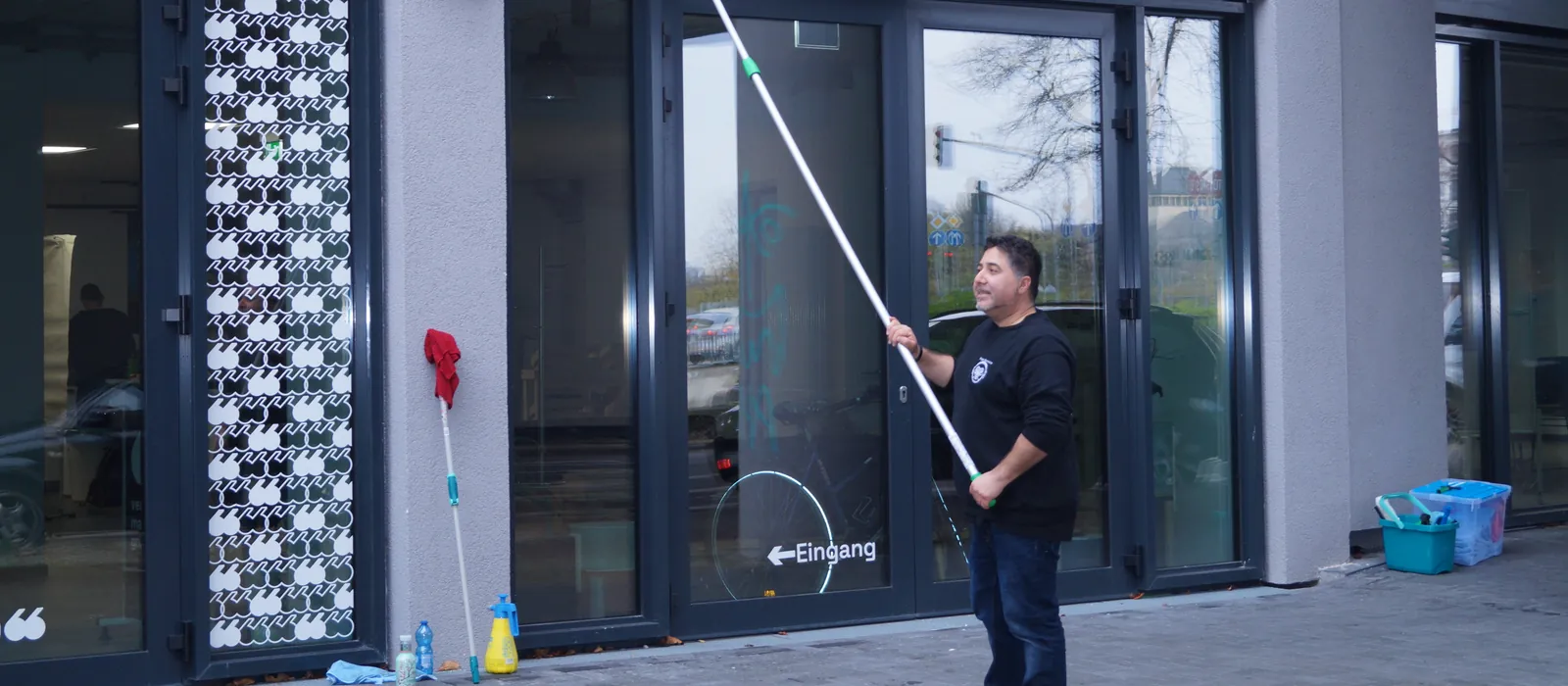 Mitarbeiter von Kaya-Service bei der Fensterreinigung mit einer Reinigungsstange