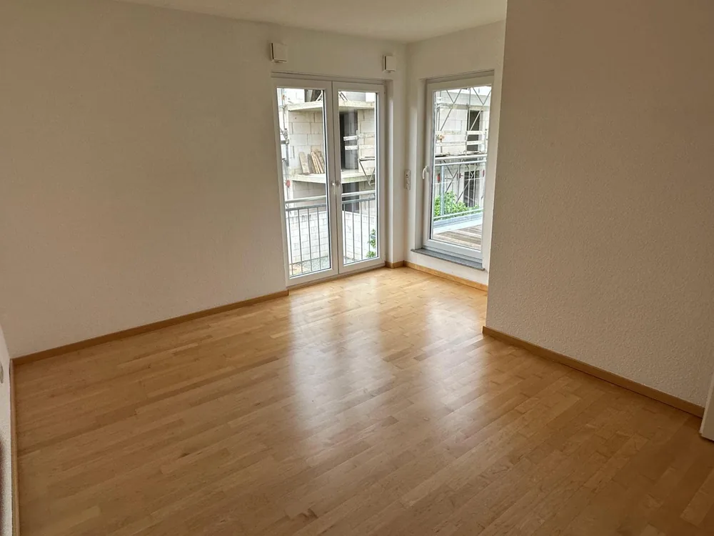 Helles, gereinigtes Zimmer mit Parkettboden und Balkontür